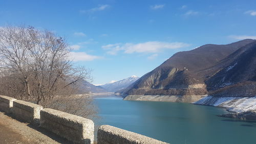 Scenic view of lake by mountains against sky