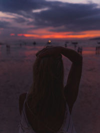 Rear view of woman on beach during sunset