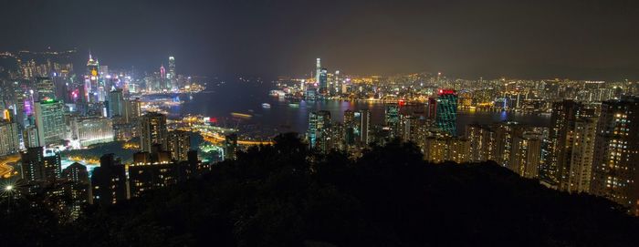 Illuminated cityscape against sky at night