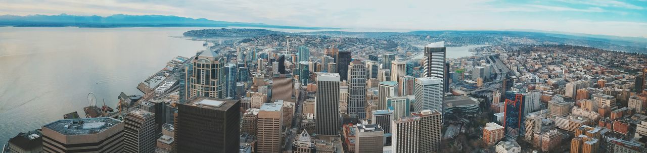 city, cityscape, building exterior, architecture, skyscraper, built structure, water, sea, crowded, sky, modern, high angle view, office building, tall - high, aerial view, tower, residential district, residential building, cloud - sky, financial district