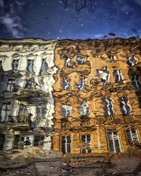 Reflection of building in water puddle on footpath