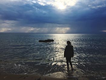 Rear view of silhouette man standing at beach