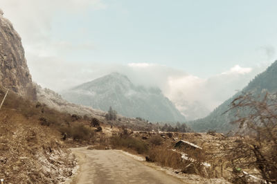 Road leading towards mountains against sky