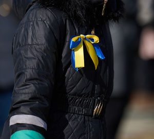 Yellow-blue ribbon on a black jacket, symbol of the ukrainian flag