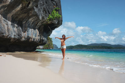 Full length of woman at beach against sky