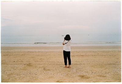 Rear view of man standing on beach