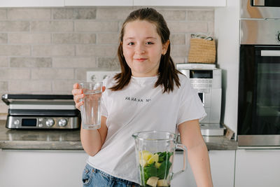 Portrait of young woman drinking glass