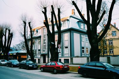 Cars on road by buildings in city