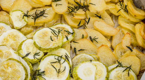 Slices of freshly baked potatoes and zucchini with dill and garlic