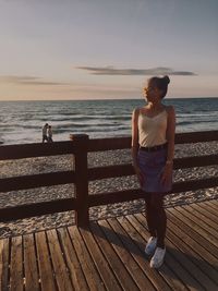 Woman standing on pier at beach 