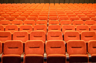 Full frame shot of orange empty chairs in theater
