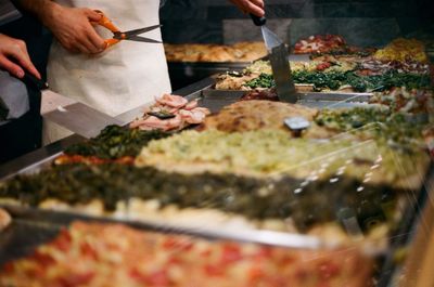 Man cutting pizza in commercial kitchen