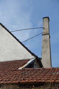 Low angle view of house roof against sky