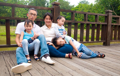 Family sitting on wooden walkway
