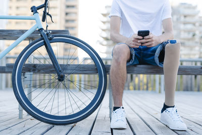 Disabled bicyclist browsing smartphone in city