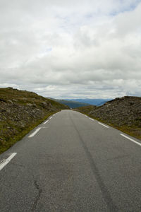 Surface level of empty road against cloudy sky