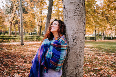 Portrait of a smiling young woman in park during autumn