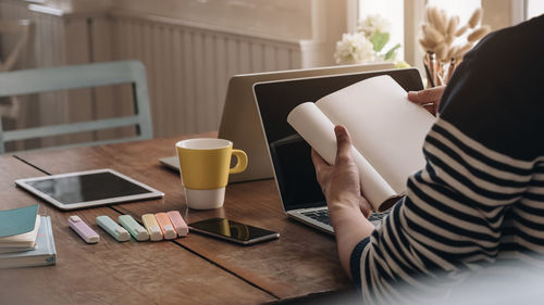 Midsection of man using laptop on table