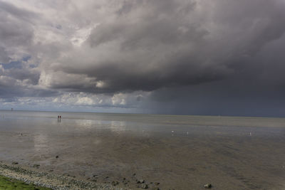 Scenic view of sea against storm clouds