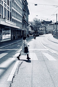 Man walking on street against buildings in city