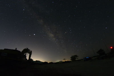 Low angle view of silhouette trees against sky at night