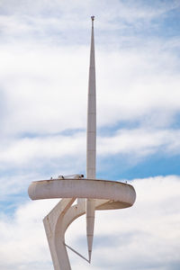Modern tower against cloudy sky
