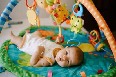 Cute baby girl lying on bed at home