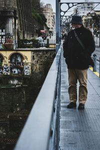 Full length of man with umbrella in city