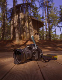 Close-up of camera on table against trees