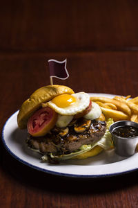 Meat burger with egg and french fries