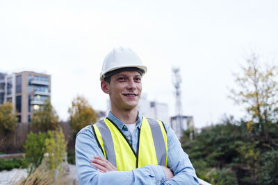 Thoughtful young engineer with arms crossed