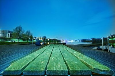 Surface level of empty road against clear blue sky