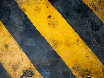 High angle view of yellow arrow symbol on road