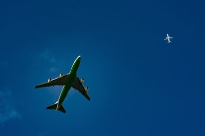 Low angle view of airplane against clear blue sky