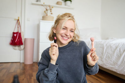 Portrait of smiling young woman sitting at home