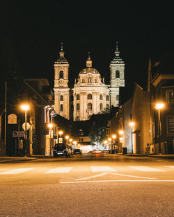 Illuminated city street and buildings at night