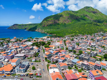 High angle view of townscape by sea against sky