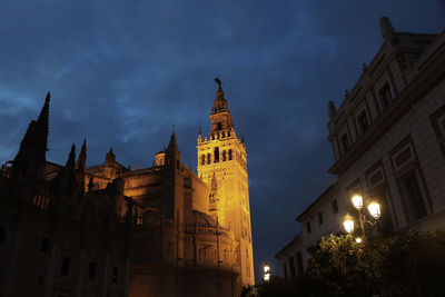 Low angle view of illuminated buildings against sky at dusk