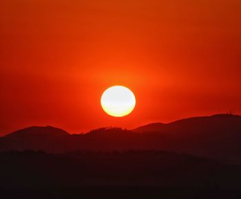 Scenic view of silhouette mountains against romantic sky at sunset