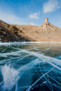 Scenic view of frozen lake against rock mountain