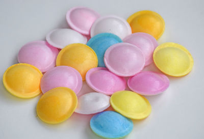 High angle view of multi colored candies against white background