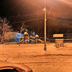 Street lights on snow covered field at night