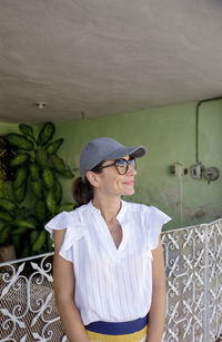 Young woman looking away while standing outdoors