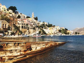 Scenic view of sea by buildings against clear sky