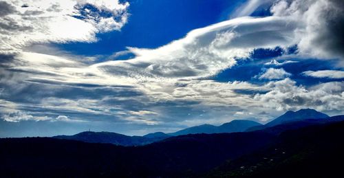 Scenic view of mountains against cloudy sky