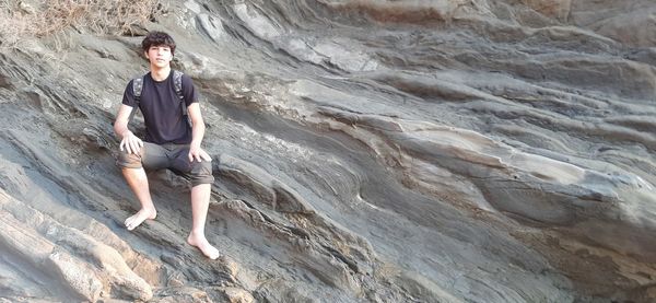 Portrait of young man standing on rock