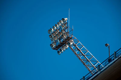 Low angle view of floodlights against clear blue sky