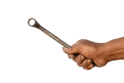 Close-up of hand holding cigarette against white background