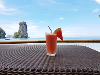 Close-up of drink on table against sea