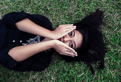 Portrait of woman lying on field